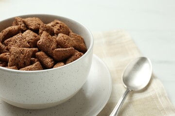 Bowl of sweet crispy corn pads on kitchen towel, closeup view with space for text. Breakfast cereal