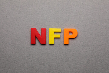 Abbreviation NFP (Nonfarm Payroll) made of letters on grey background, top view