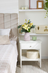 Fototapeta na wymiar Bouquet of beautiful flowers on nightstand in bedroom