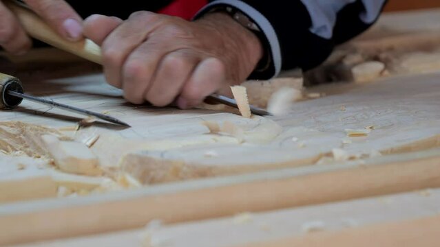 The carpenter creates a carved picture. Hands of the master close-up