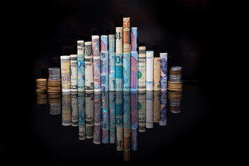 Banknotes of several international currencies rolled up side by side as if they were buildings of a city