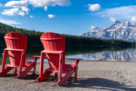 Two Jack Lake with the iconic red adirondack chairs at the shoreline in Banff National Park