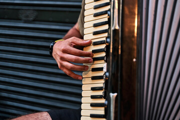 close up shot of a young man playing accordion on a tourist street in portugal lisbon, asking for...