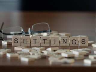 settings word or concept represented by wooden letter tiles on a wooden table with glasses and a...