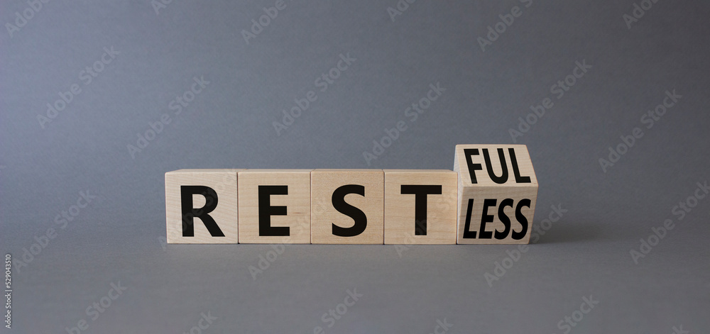 Fototapete restful and restless symbol. turned wooden cubes with words restless and restful. beautiful grey bac