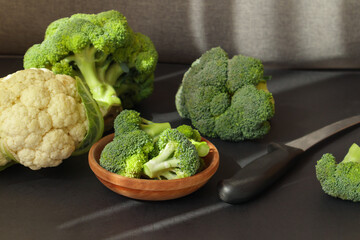 Fresh green broccoli in brown wooden bowl.
