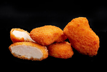 A pile of chicken nuggets isolated on black color background