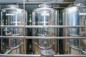 A stainless steel vat in the food industry at a brewery in the process of brewing beer. Background