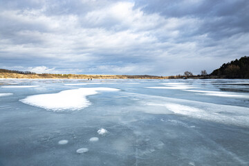 Winter landscape on a frozen river at sunset, heavy frost and a frozen river in winter, everything is covered with snow