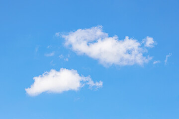 Naklejka na ściany i meble White clouds against a clear blue sky, warm summer day