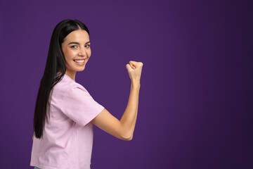 Strong woman as symbol of girl power on purple background, space for text. 8 March concept