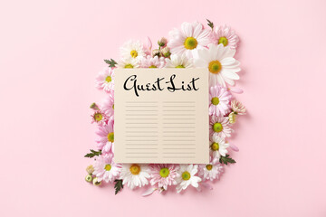 Beautiful chamomile flowers and guest list on pink background, flat lay