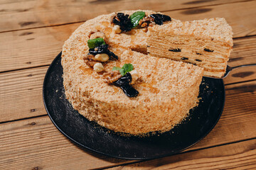 We can see a yummy cake on the wooden table of the restaurant.