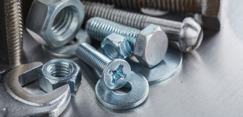 set of different nuts, bolts, screws, washers and drill bits,thread tap and mill cutters on steel plate background. Locksmithing deal.