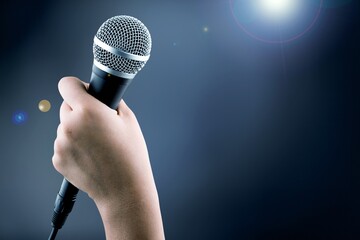 Classic black microphone with stage lighting background