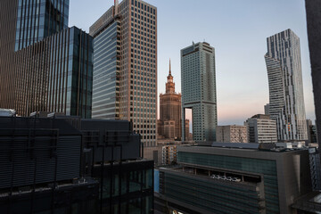 Amazing modern European city of Warsaw, Poland with its tall office buildings and the historic Palace of Culture. Urban backdrop with buildings. Downtown at evening