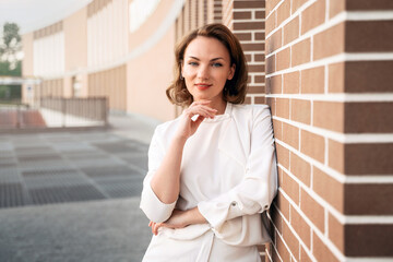 Portrait of smiling confident business woman wearing stylish clothing looking at camera standing...