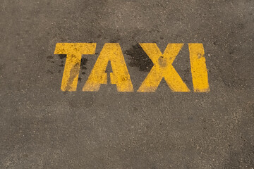 yellow inscription on the road signifying a place for parking taxi cars within the city, Urban public transport infrastructure.