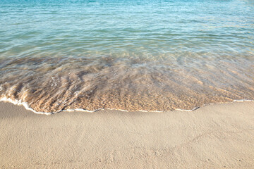 Ocean waves at the shore of a white sand beach