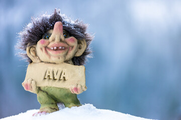 Fototapeta na wymiar Smiling troll holding a name plate with the name Ava chiseled out in stone. Popular name concept.