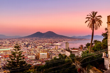 Fototapeta na wymiar Napoli, Italy - July 11, 2021: Bay of Napoli and Vesuvius volcano in background at sunset in a summer day in Italy, Campania