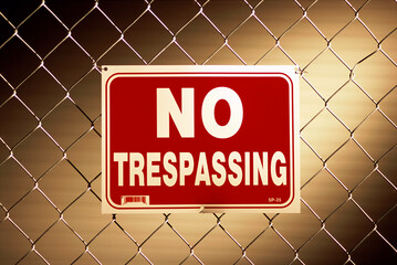 No trespassing sign on a chain-link fence - obrazy, fototapety, plakaty