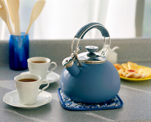 Close-up of two coffee cups and a kettle