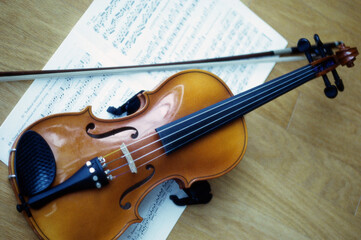 Fototapeta na wymiar Violin and a bow on music sheets