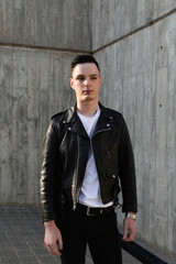 Handsome smiling stylish hipster young man. Fashion male posing in the street. 