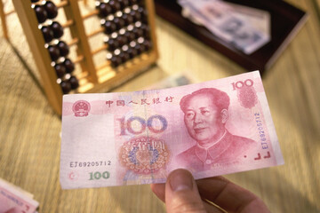Person's hand holding Yuan banknotes