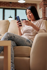 Obraz premium Asian woman buying online doing shopping using credit card on phone, smartphone credit happy female pay internet web purchase payment money customer asia app payment