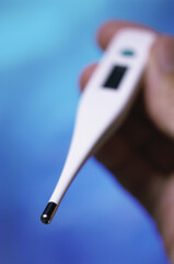 Close-up of a person holding a digital thermometer
