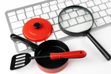 キーボードとオモチャの料理道具。レシピをネットで調べるイメージ