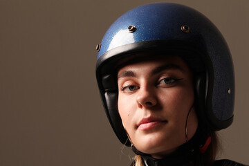 Close-up portrait of young woman wearing motor helmet poses indoor. Mock-up. 