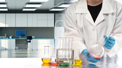 Man laboratory assistant. Multi-colored liquids in chemical flasks. laboratory assistant with test tubes. Chemist works in modern office. Lab worker conducts experiments. Lab flasks of various shapes