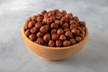 Top view of a bowl full of hazelnuts on bright background
