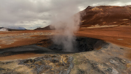SMOKING GEYER ON THE STONE ROAD TO THE SMOKING LITTLE GEYSER. ICELAND'S VOLCANIC LANDSCAPE.