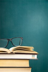 A stack of books on background. School equipment, tools, learning and education concept.