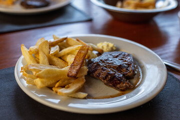 plate of beef tenderloin with french fries in restaurant