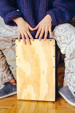 unrecognizable female percussionist at home playing the peruvian caja, a relaxing Sunday. vertical photo