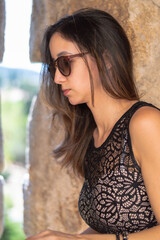 Portrait young attractive woman with sunglasses standing over isolated stone background