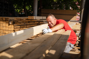 One man choose wood plank at warehouse or construction site