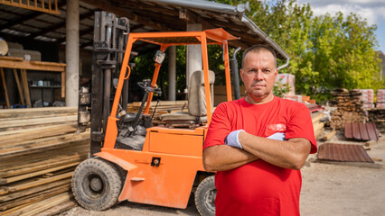 One man worker standing in front of the fork lifter at warehouse