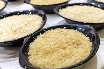 Raw rice in black bowl and white background