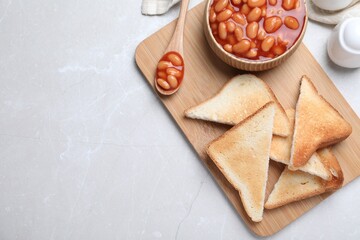 Toasts and delicious canned beans on white table, flat lay. Space for text
