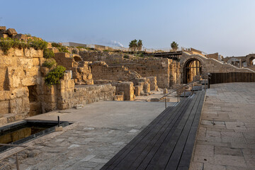 CAESAREA, Israel - August 2022, Roman emperor statue reflecting in a pool, Numerous tourists visit...