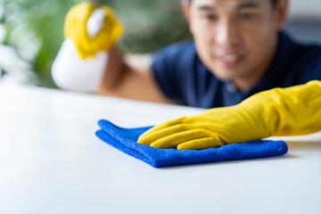 Close-up, restaurant staff's hands are cleaning table surfaces and spraying disinfectant during the virus outbreak. Use a cleaner or use alcohol to disinfect the restaurant.