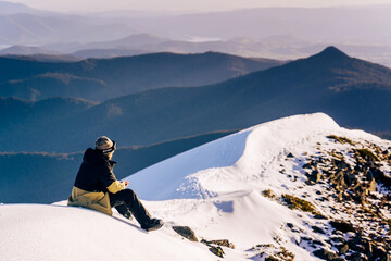 man sitting on the snow with mountains landscape