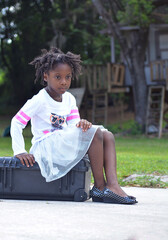 little girl sitting on a suitcase