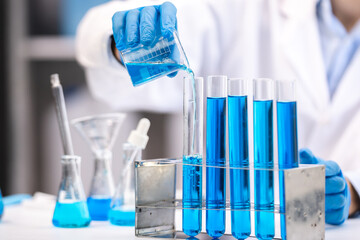 blue chemical liquid experiment in scientific glassware equipment in science medicine laboratory, chemistry or biology research discovery by using glass of test tube or beaker and flask